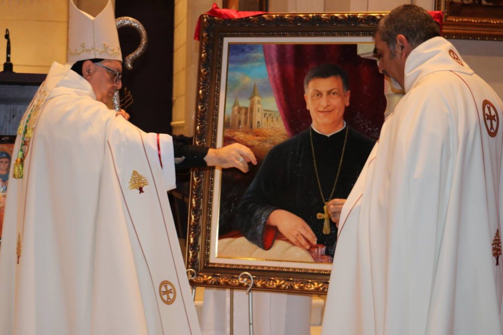 Monsignor Raymond Hanna standing beside parishioners.