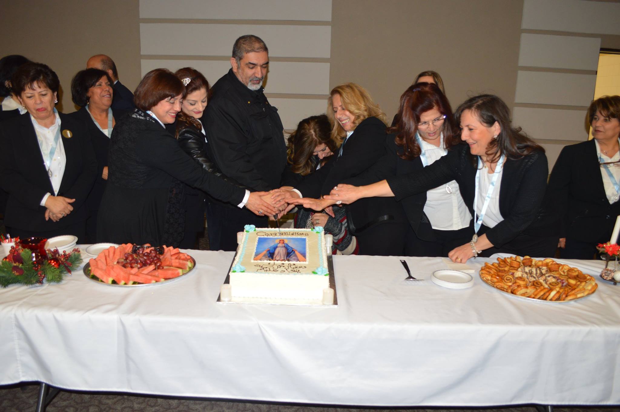 Leaders cutting the Annual Lenten Lunch cake together